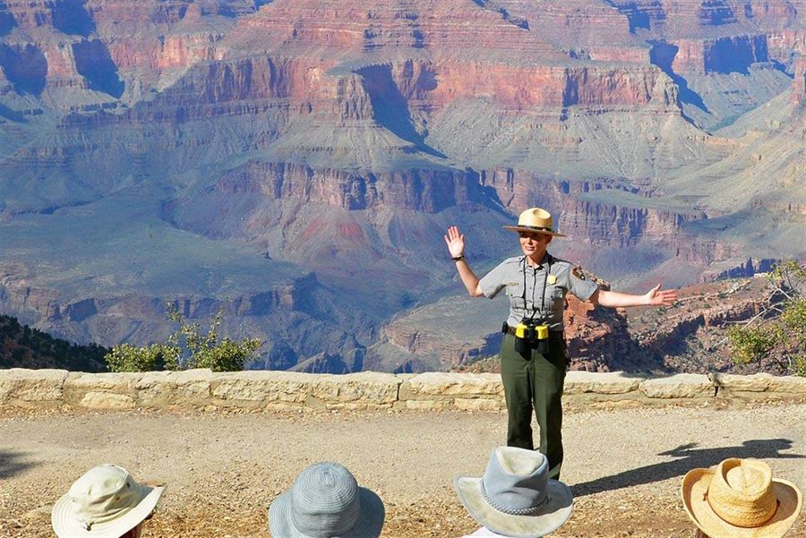 A National Park Service ranger speaks with visitors at a Grand Canyon overlook during a calm, informational safety talk