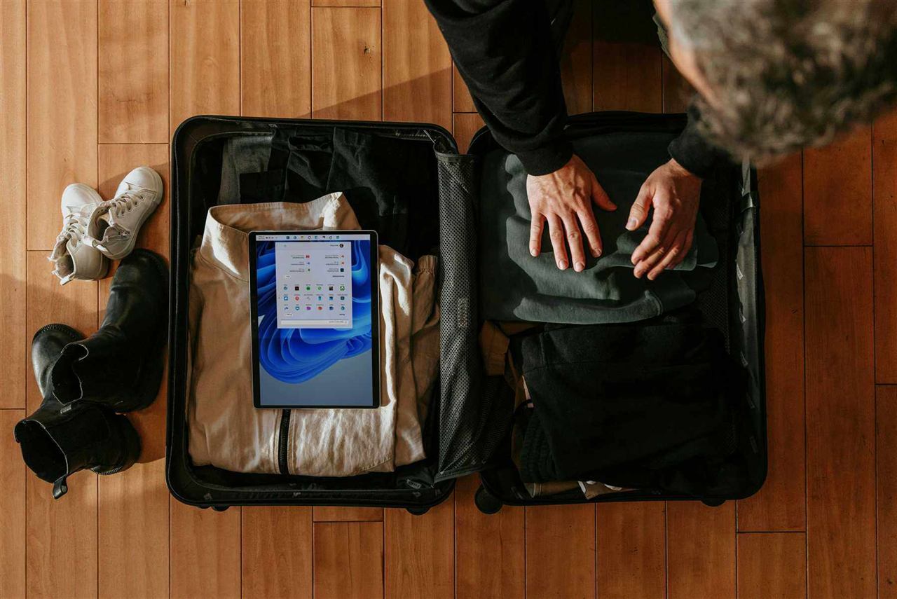 Overhead view of a suitcase being packed with travel essentials