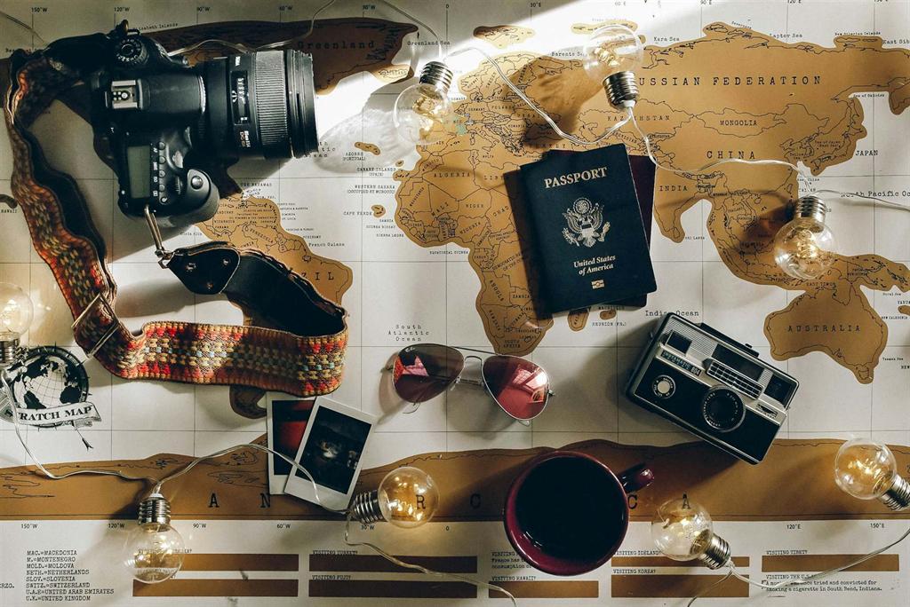 A travel planning flat lay with a camera, passport, map, and coffee, ready for an Arizona trip