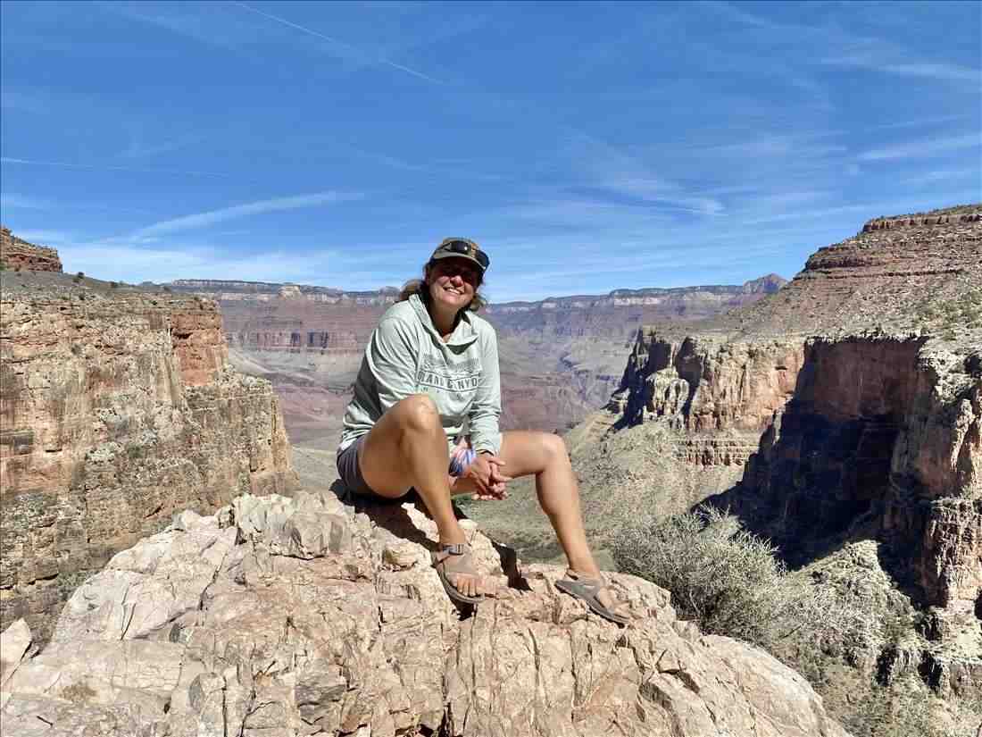 A hiker resting on a rock overlook deep in the Grand Canyon