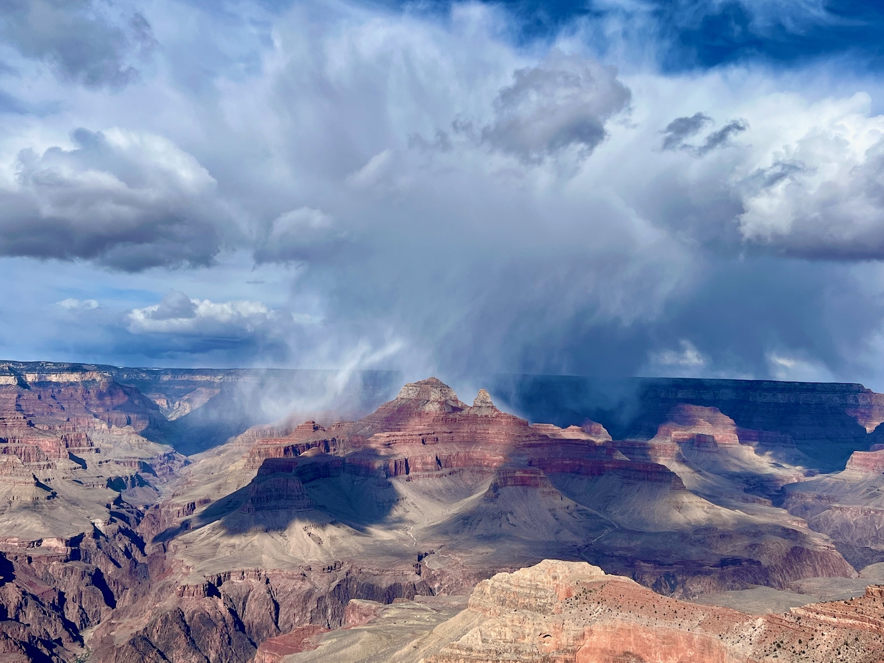 A monsoon storm cell dropping rain over the Grand Canyon