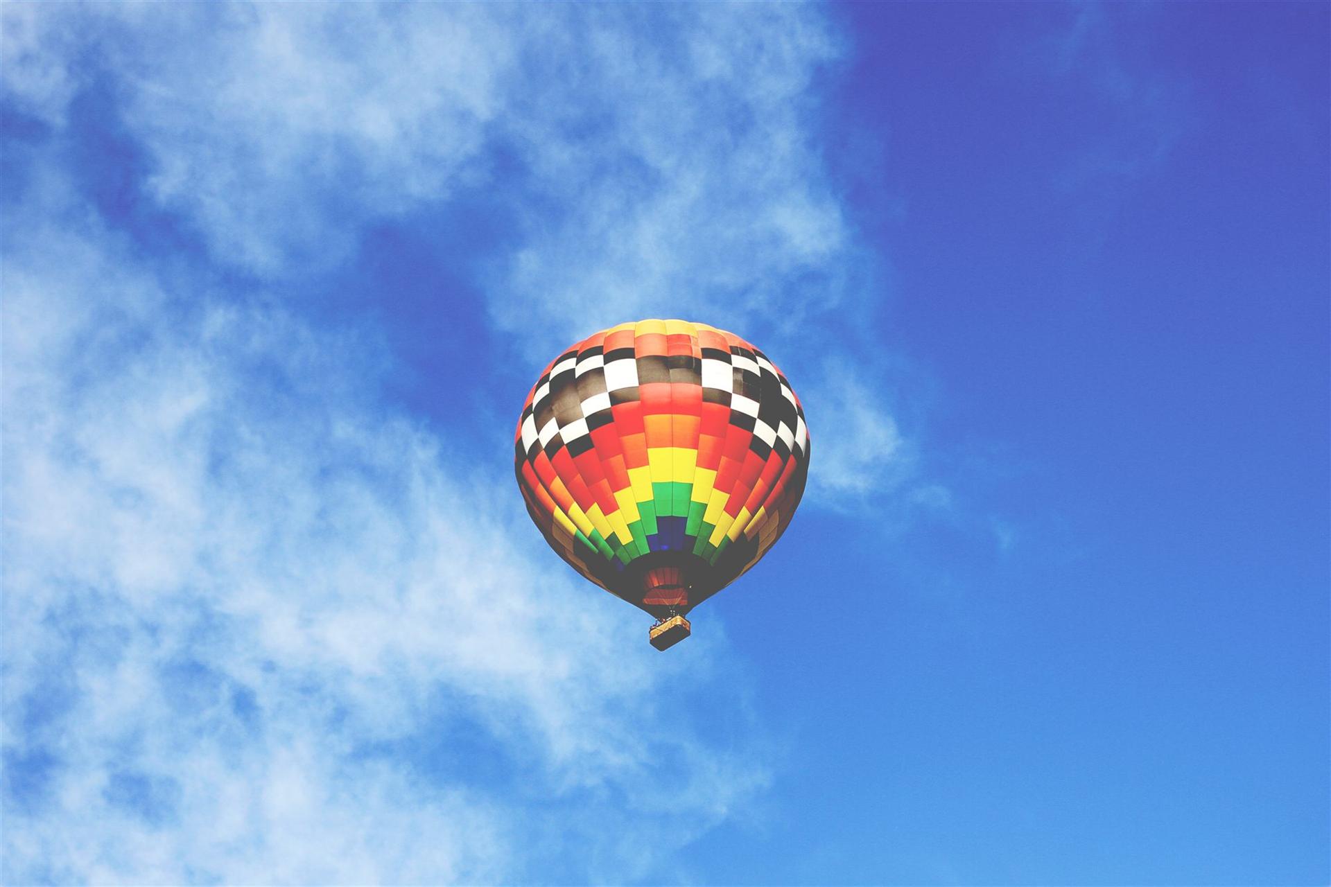 Colorful hot air balloon rising into a blue Arizona sky