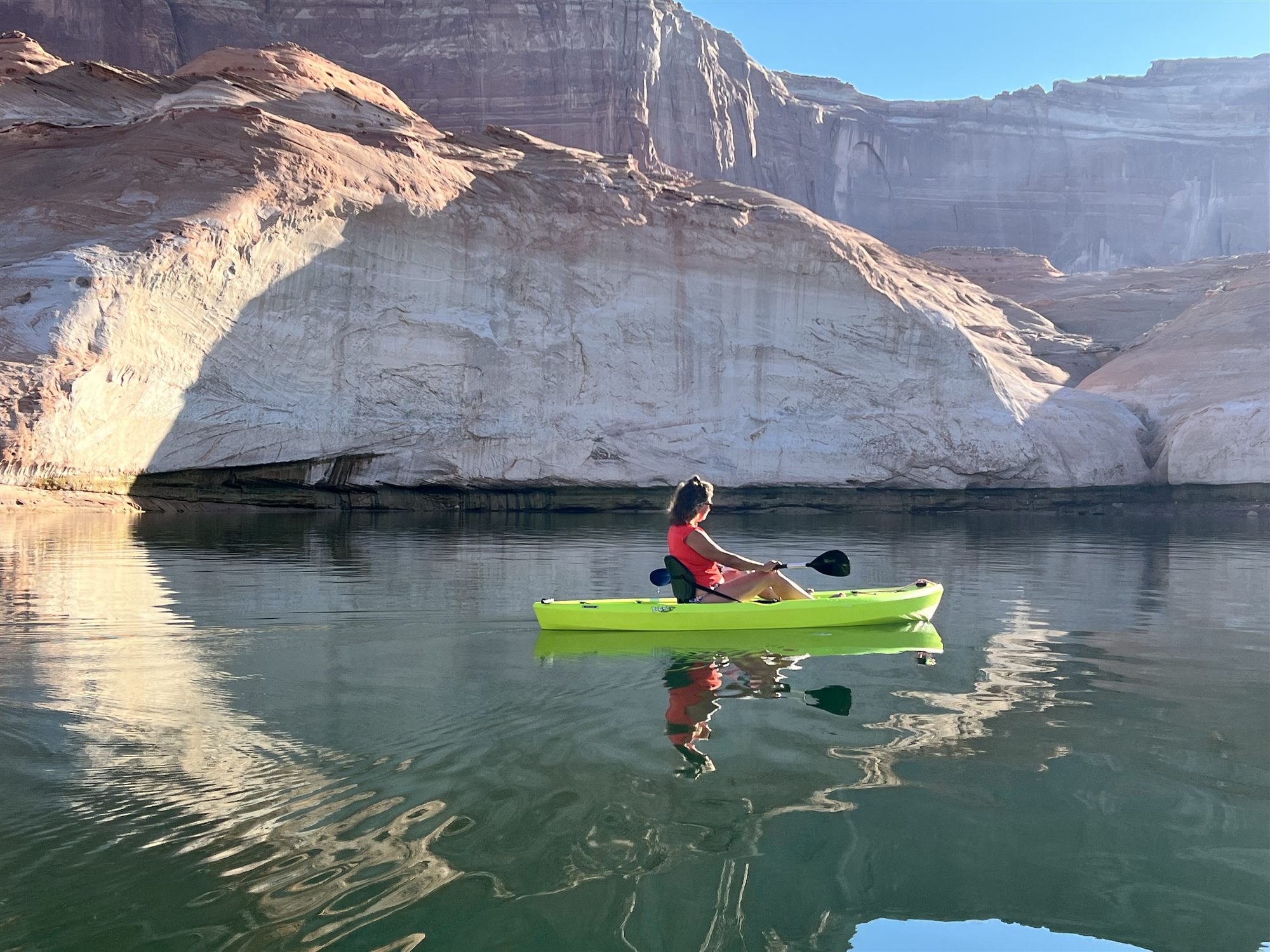 Kayaking on the calm waters of Lake Powell beneath towering sandstone cliffs, Arizona