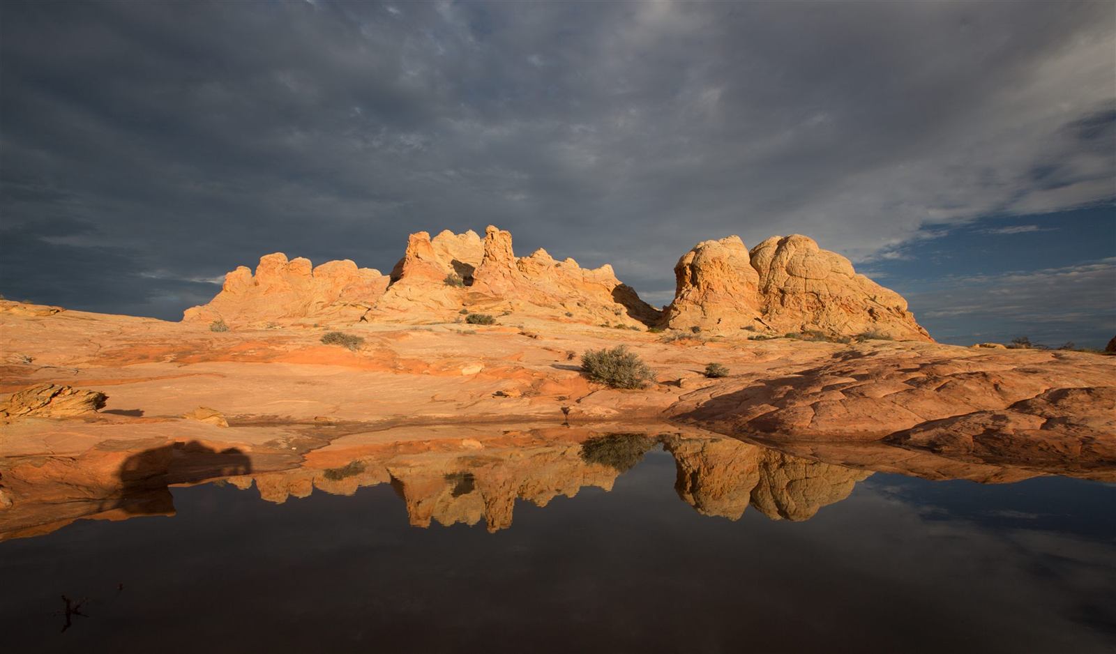 Striped orange and red sandstone formations reflected in a still pool at Vermilion Cliffs National Monument, Arizona (BLM photo)